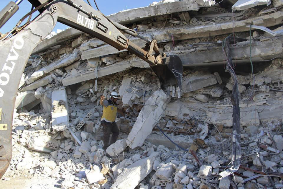 This photo provided by the Syrian Civil Defense White Helmets, which has been authenticated based on its contents and other AP reporting, shows Syrian White Helmet civil defense workers at the scene of an explosion that brought down a five-story building, in the village of Sarmada, near the Turkish border, north Syria, Sunday, Aug. 12, 2018. Syrian opposition activists say the explosion killed several people and wounded many others. The cause of the blast wasn't immediately known. (Syrian Civil Defense White Helmets via AP)