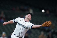 Seattle Mariners third baseman Kyle Seager reaches to snag a pop up from Oakland Athletics' Mark Canha in the eighth inning of a baseball game Monday, Sept. 27, 2021, in Seattle. (AP Photo/Elaine Thompson)