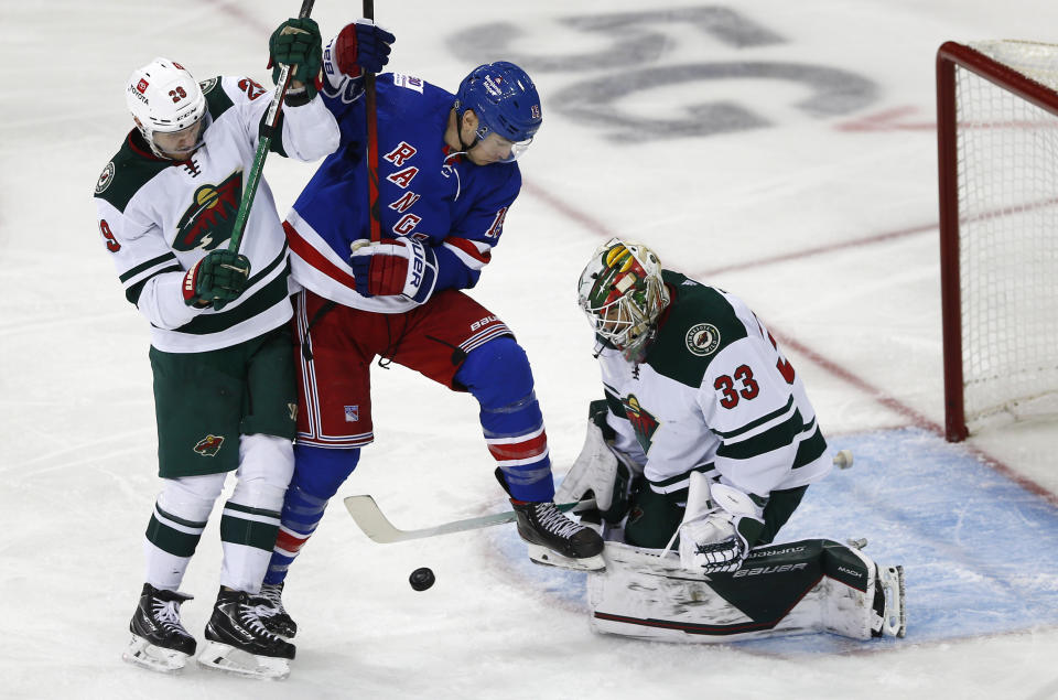 Minnesota Wild's Cam Talbot (33) makes a save while teammate Dmitry Kulikov (29) and New York Rangers' Julien Gauthier (15) battle in front of the crease during the third period of an NHL hockey game Friday, Jan. 28, 2022, in New York. (AP Photo/John Munson)