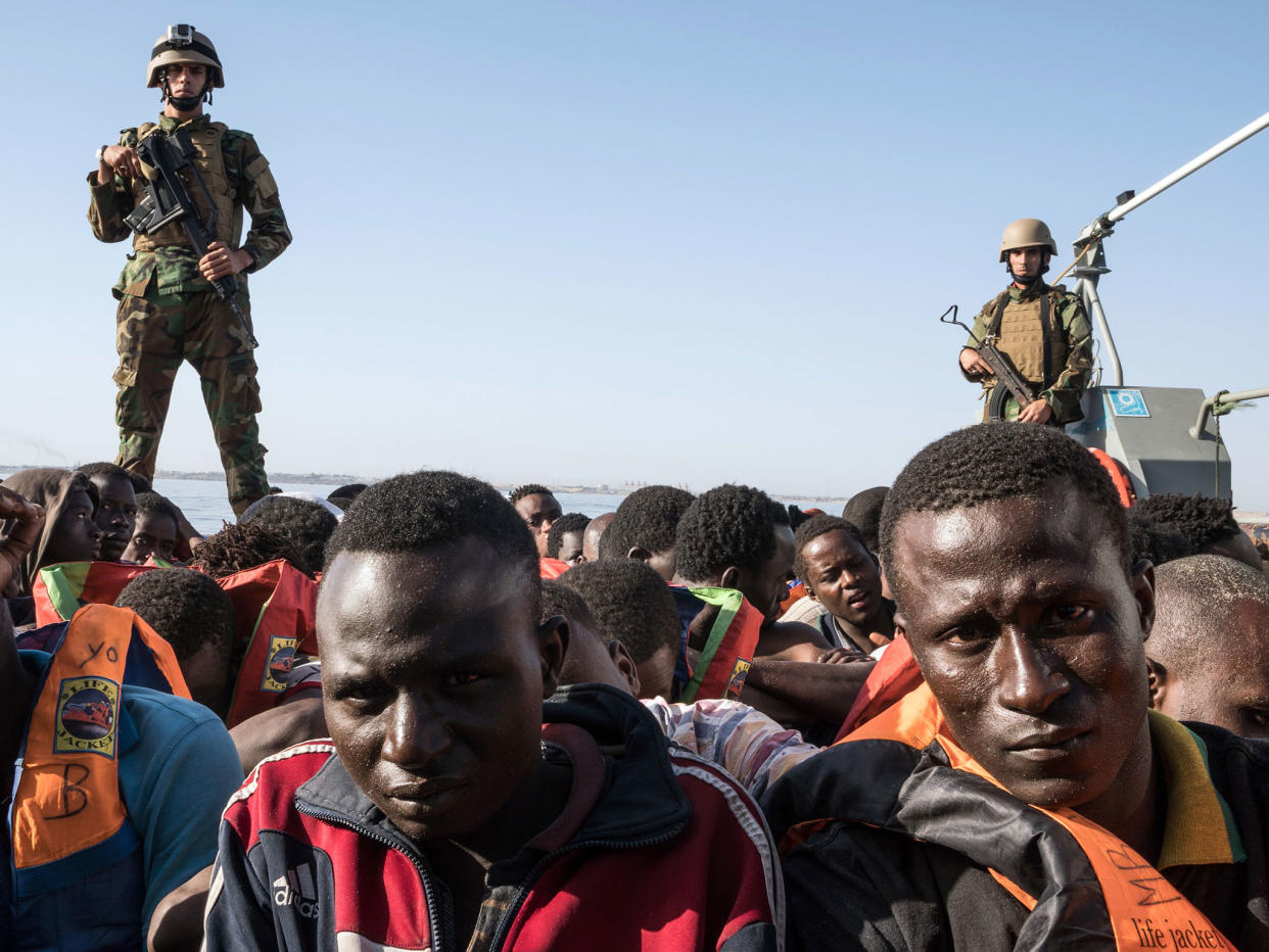 Members of the Libyan coastguard stand on a boat while detaining 147 migrants attempting to reach Europe off the coastal town of Zawiyah on 27 June 2017: Getty