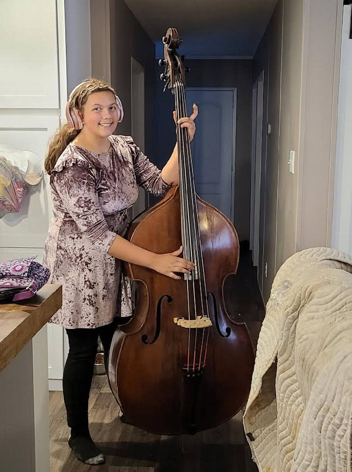 Bellamie Fleming playing an instrument donated by WoodSongs. Credit: Polly Fleming