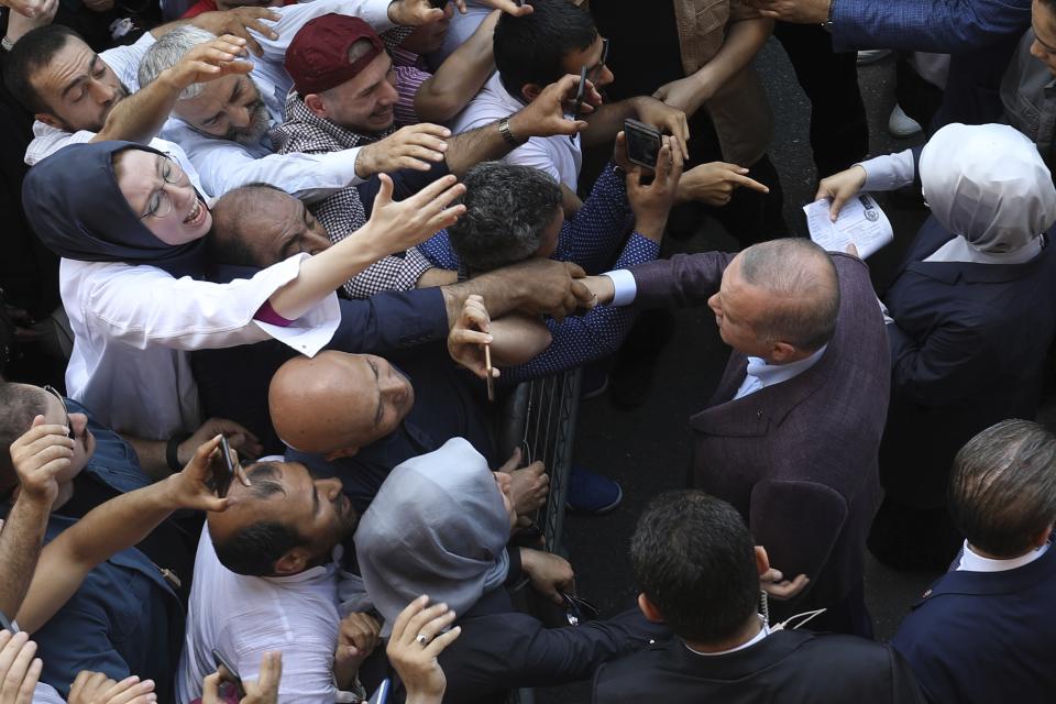 Turkey's President Recep Tayyip Erdogan shakes hands with his supporters outside a polling station in Istanbul, Sunday, June 23, 2019. Voters in Istanbul returned to the polls Sunday for a re-run mayoral election ordered up by authorities after Erdogan and his political allies lost control of Turkey's largest city for the first time in 25 years. (AP Photo/Emrah Gurel)