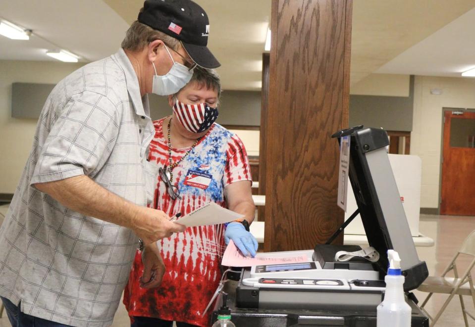 Ottawa County precinct worker Kay Boman Harvey helps Ronnie Barnes feed his ballots into the voting machine at the Miami Civic Center in this 2020 file photo. Ottawa County, located in Oklahoma's northeast corner, gets its TV news from the Joplin, Missouri, market. It ranked 74th among the state's 77 counties for voter turnout, with less than half of its registered voters casting a ballot in the 2022 gubernatorial election.