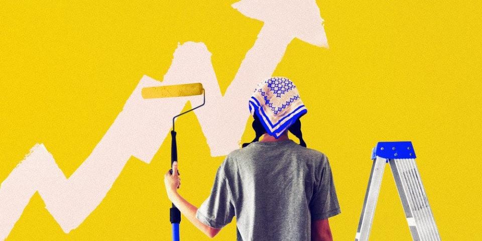 A person painting a wall yellow. There's an arrow in paint on the wall in an upwards direction.