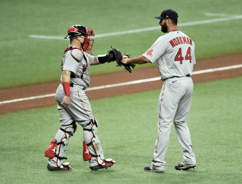 Boston Red Sox catcher Christian Vazquez, left, and closer Brandon Workman celebrate the team's 5-0 win over the Tampa Bay Rays in a baseball game Wednesday, Aug. 5, 2020, in St. Petersburg, Fla. (AP Photo/Steve Nesius)
