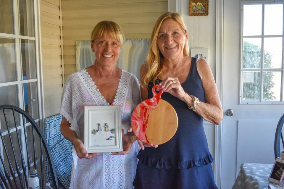 Debbie Prue, left, will teach classes on creating art with beach glass at The Arts Garage this month. Judy Prue, right, holds one of her hand painted charcuterie boards.