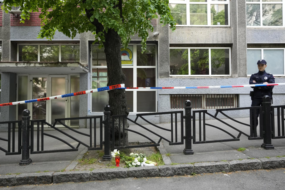 Policeman stands in front of the Ribnikar school in Belgrade, Serbia, Wednesday, May 3, 2023. Police say a 13-year-old who opened fire at his school drew sketches of classrooms and made a list of people he intended to target. He killed eight fellow students and a school guard before being arrested Wednesday. (AP Photo/Darko Vojinovic)