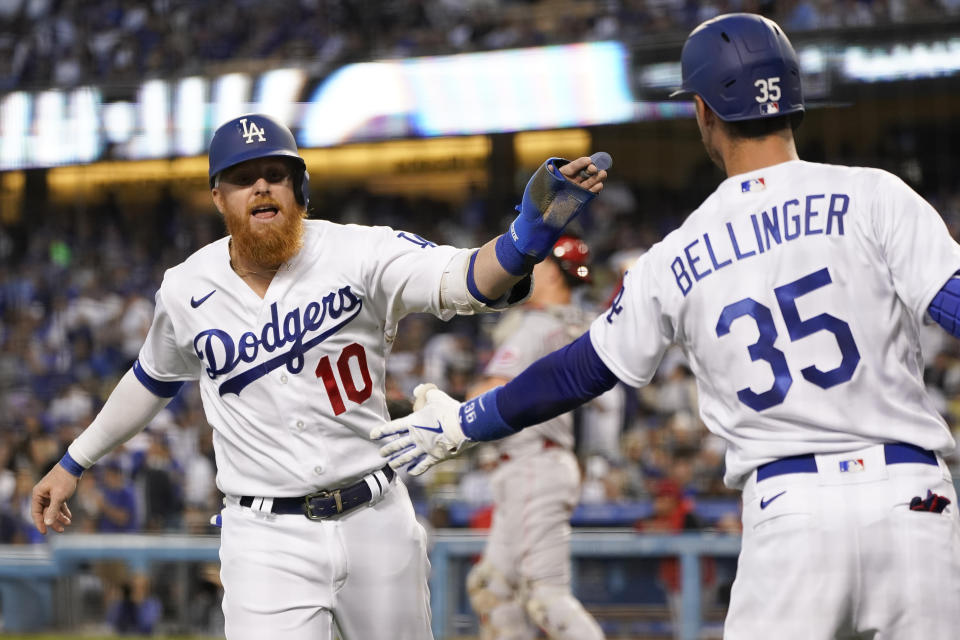 Los Angeles Dodgers designated hitter Justin Turner (10) celebrates with Cody Bellinger (35) after Turner scored off of a single hit by Will Smith during the first inning of a baseball game against the Cincinnati Reds in Los Angeles, Thursday, April 14, 2022. (AP Photo/Ashley Landis)