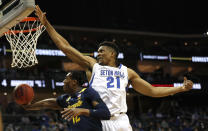Marquette forward Olivier-Maxence Prosper (12) drives to the basket against Seton Hall center Ike Obiagu (21) during the first half of an NCAA college basketball game in Newark, N.J., Wednesday, Jan. 26, 2022. (AP Photo/Noah K. Murray)