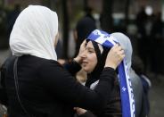 A demonstrator adds a Quebec flag to her veil during a protest against Quebec's proposed Charter of Values in Montreal, September 14, 2013. Thousands took to the streets to denounce the province's proposed bill to ban the wearing of any overt religious garb by government paid employees. REUTERS/ Christinne Muschi(CANADA - Tags: POLITICS CIVIL UNREST RELIGION)