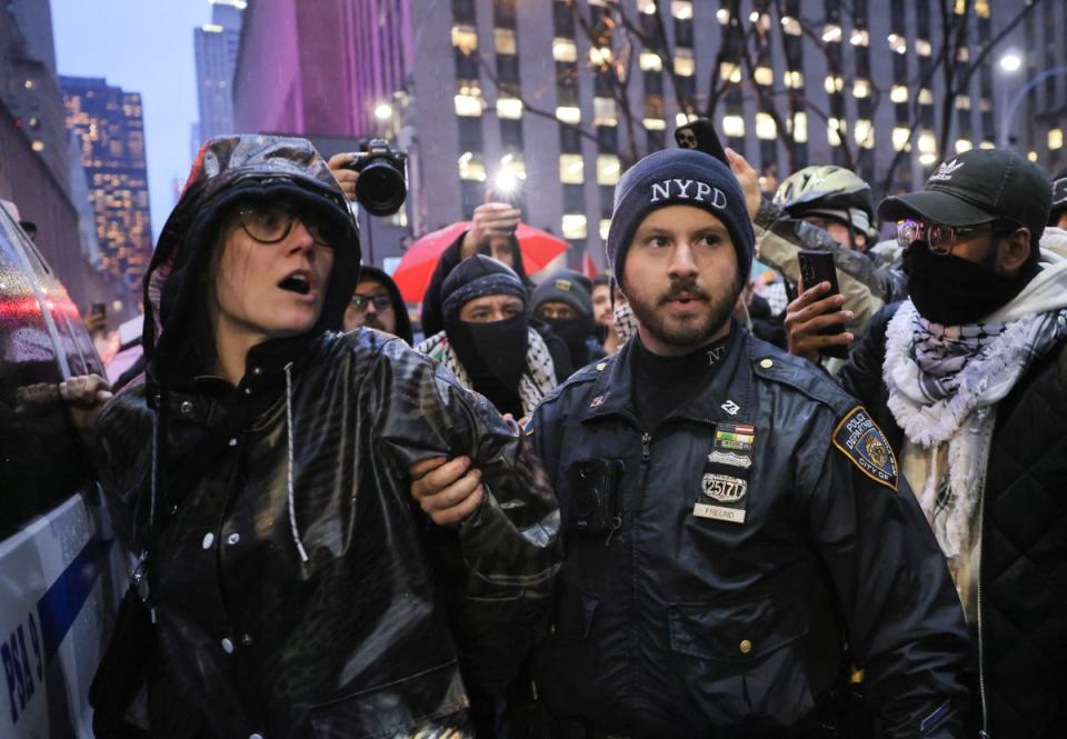 A protester is detained outside the venue (REUTERS)