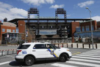 FILE - In this March 24, 2020, file photo, a Police vehicle blocks a street near Citizens Bank Park, home of the Philadelphia Phillies baseball team, in Philadelphia. On MLB’s opening day, ballparks will be empty with the start of the season on hold because of the coronavirus pandemic. (AP Photo/Matt Slocum, File)