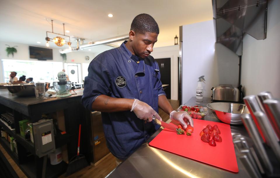 Owner and chef Keith Brown preps strawberries in the kitchen at the Toast Factory.