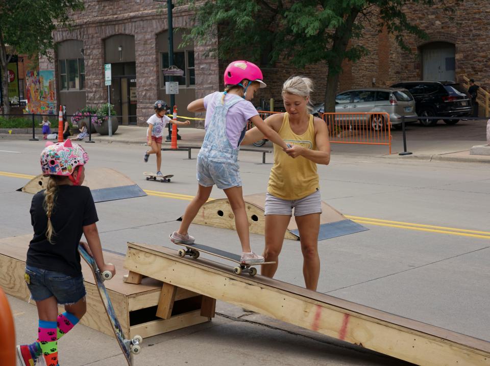 A young skater gets some help on a wooden rail during Innoskate in downtown Sioux Falls on Saturday, July 9, 2022.