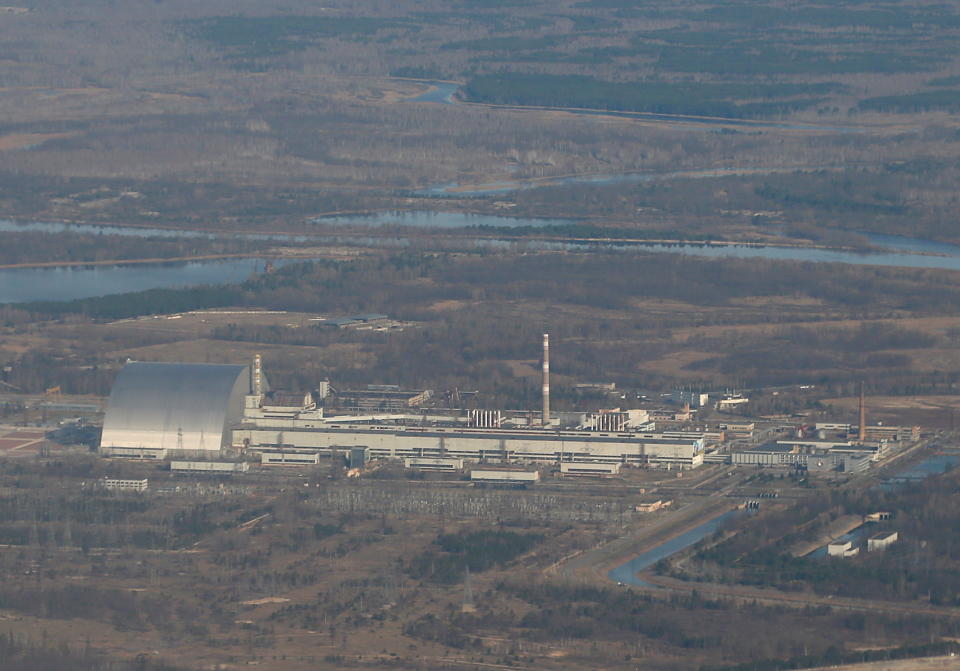 An aerial view from a plane shows a New Safe Confinement (NSC) structure over the old sarcophagus covering the damaged fourth reactor at the Chernobyl Nuclear Power Plant during a tour to the Chernobyl exclusion zone, Ukraine April 3, 2021. Ukraine International Airlines made a special offer marking the 35th anniversary of the Chernobyl nuclear disaster. Tourists get a bird's eye view of abandoned buildings in the ghost town of Pripyat and the massive domed structure covering a reactor of the Chernobyl Nuclear Power Plant that exploded on April 26, 1986. Picture taken April 3, 2021. REUTERS/Gleb Garanich