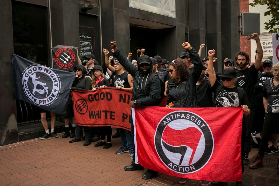 Members of Antifa get in formation after entering the security checkpoint required to enter the mall in downtown Charlottesville, Va. on Aug. 11, 2018 one-year after the violent white nationalist rally that left one person dead and dozens injured.