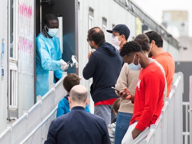 People wait to be tested for COVID-19 at a clinic in Montreal on Sunday. Quebec public health reported 154 new infections on Monday. (Graham Hughes/The Canadian Press - image credit)