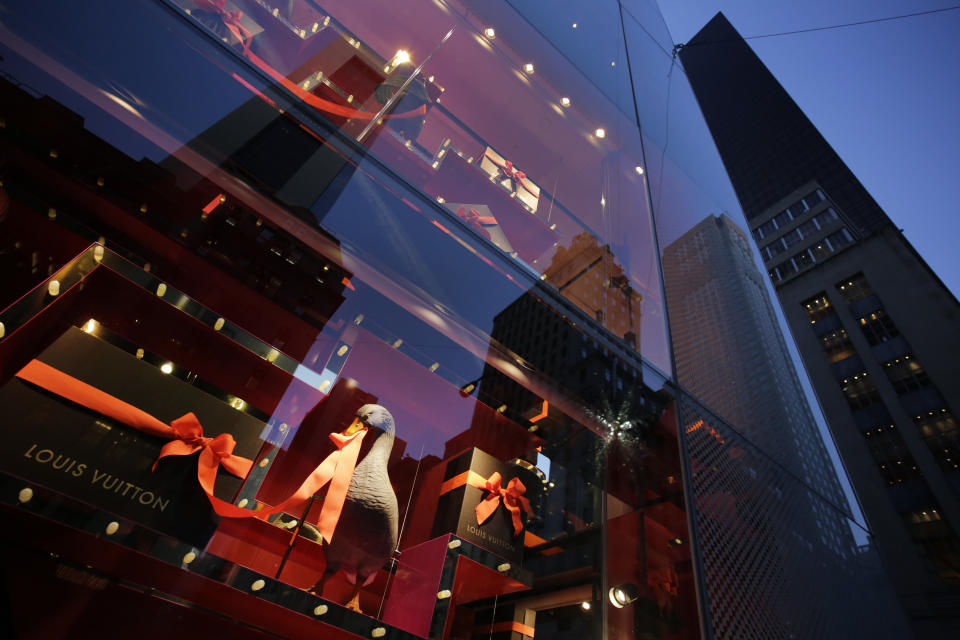 This Nov. 20, 2013 photo shows a goose pulling the ribbon on a gift-wrapped package in a holiday window display at Louis Vuitton in New York. Forget window shopping, some of Manhattan’s biggest and most storied retailers say their elaborate seasonal window displays are a gift to passers-by. (AP Photo/Mark Lennihan)