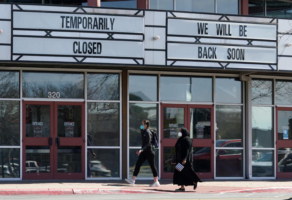 Shoppers pass a theater closed due to the COVID-19 outbreak, Wednesday, March 3, 2021, in San Antonio. Gov. Greg Abbott says Texas is lifting a mask mandate and lifting business capacity limits next week. (AP Photo/Eric Gay)