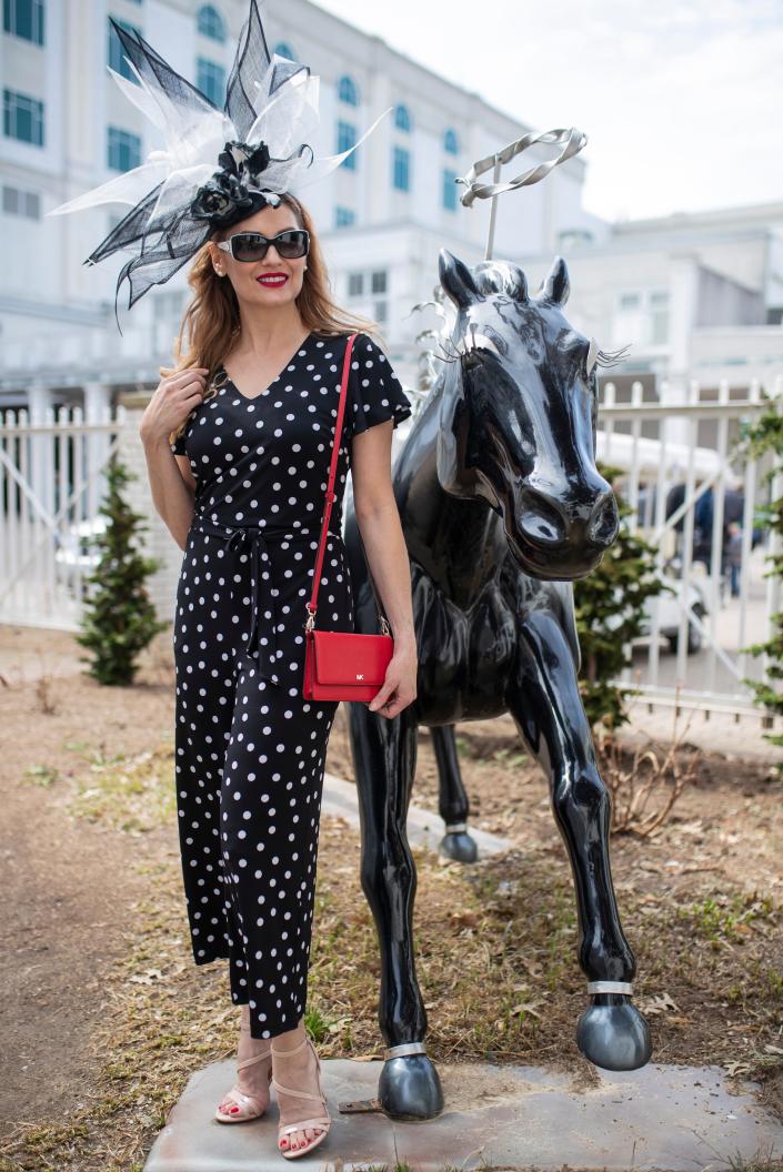 Model Hope Daniels wears a black and white Giovanno headband ($395), black and white Brighton sunglasses ($80), black and white dotted Frank Lyman jumpsuit ($198), and a red Michael Kors tiny bag ($128) during a Kentucky Derby fashion shoot with stylist Jo Ross at Churchill Downs. March 28, 2019