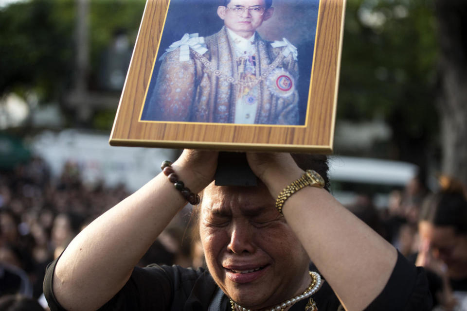 <p>A Thai woman holding up a picture of the late King Bhumibol Adulyadej cries while waiting for a van carrying his body outside the Grand Palace in Bangkok, Oct. 14, 2016. Bhumibol, the world’s longest reigning monarch, died Thursday at 88. (Photo: Wason Wanichakorn/AP)</p>