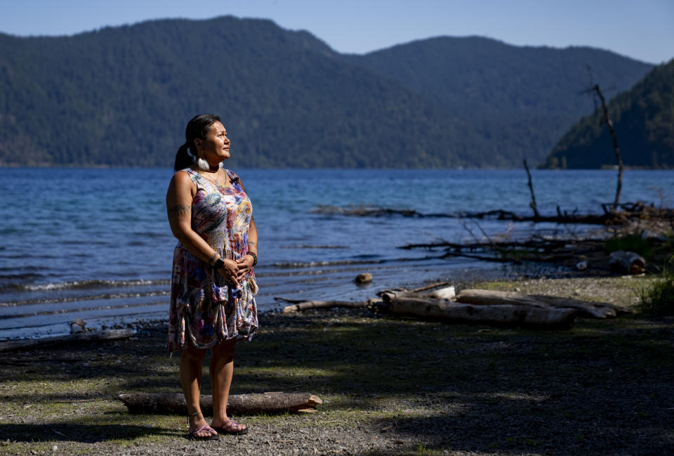 Jeanette Kiokun, the tribal clerk for the Qutekcak Native Tribe in Seward, Alaska, poses for a portrait on the shore of Lake Crescent at NatureBridge in the Olympic National Park during the 2023 Tribal Climate Camp, Thursday, Aug. 17, 2023, near Port Angeles, Wash. Participants representing at least 28 tribes and intertribal organizations gathered to connect and share knowledge as they work to adapt to climate change that disproportionally affects Indigenous communities. More than 70 tribes have taken part in the camps that have been held across the United States since 2016. (AP Photo/Lindsey Wasson)