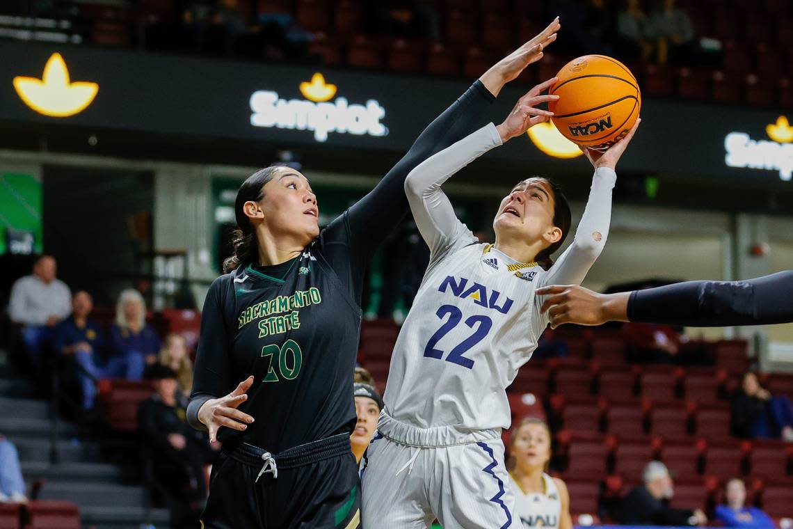 Northern Arizona guard Olivia Moran (22) battles to get her shot off against Sacramento State guard Katie Peneueta (20) in the first half of an NCAA college basketball game for the championship of the Big Sky women’s tournament in Boise, Idaho, Wednesday, March 8, 2023, in Boise, Idaho. (AP Photo/Steve Conner)