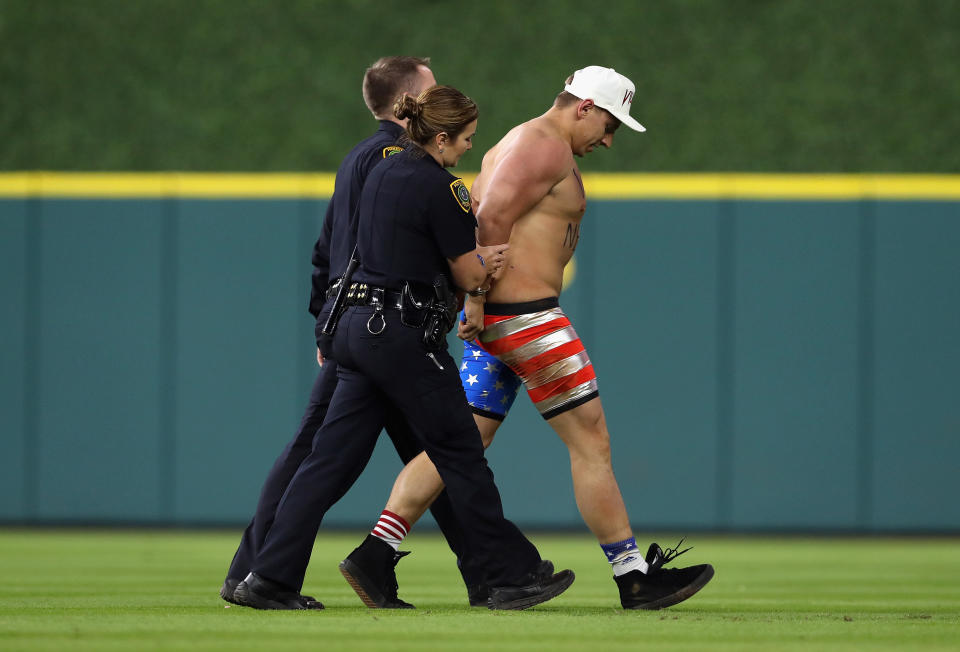 Security workers&nbsp;escort&nbsp;Vitaly Zdorovetskiy&nbsp;off the field. (Photo: Christian Petersen/Getty Images)