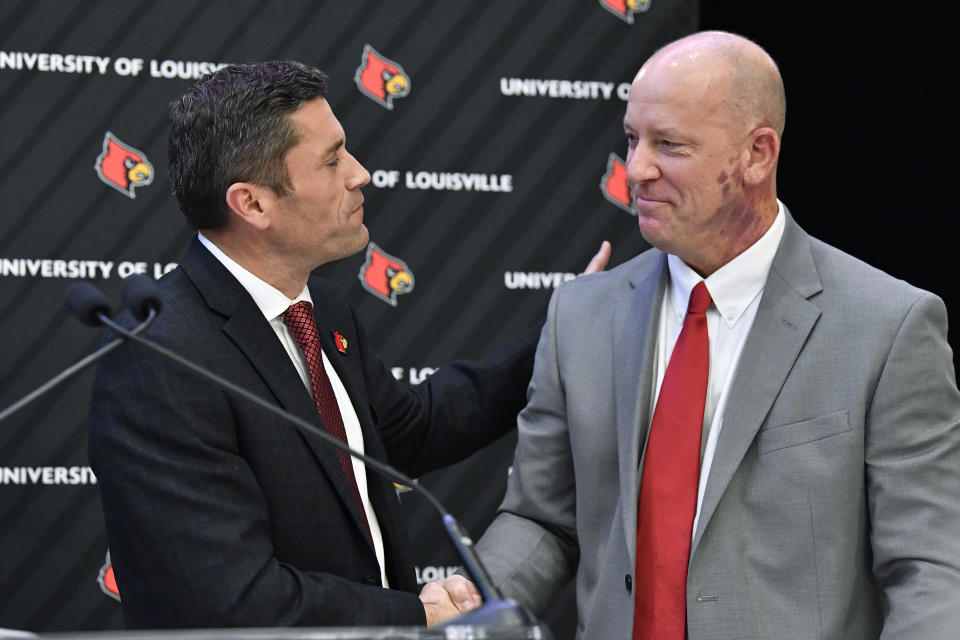 Louisville athletic director Josh Heard, left, shakes hands with newly named football coach Jeff Brohm in Louisville, Ky., Thursday, Dec. 8, 2022. (AP Photo/Timothy D. Easley)
