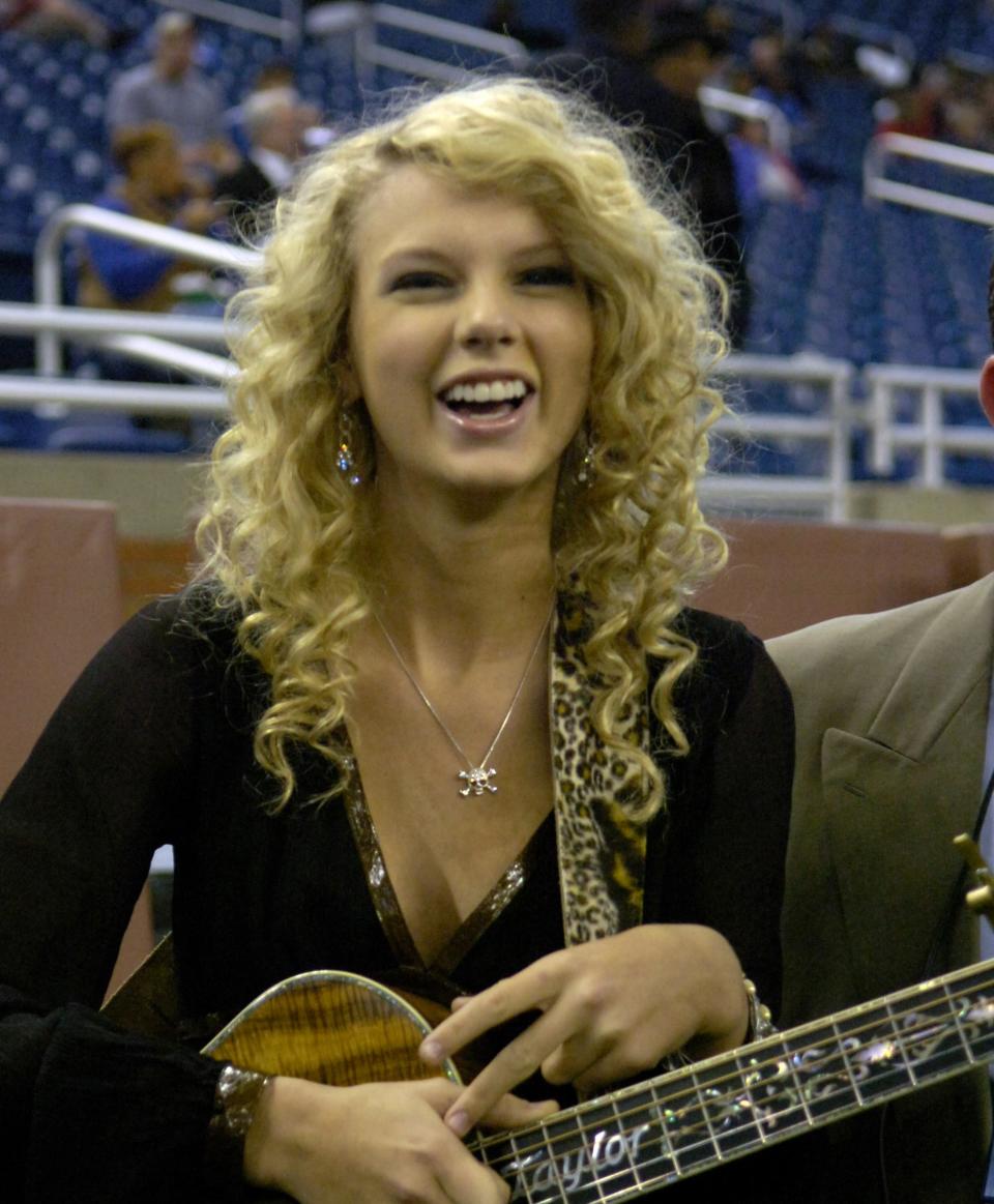 Close-up of Taylor smiling and holding a guitar