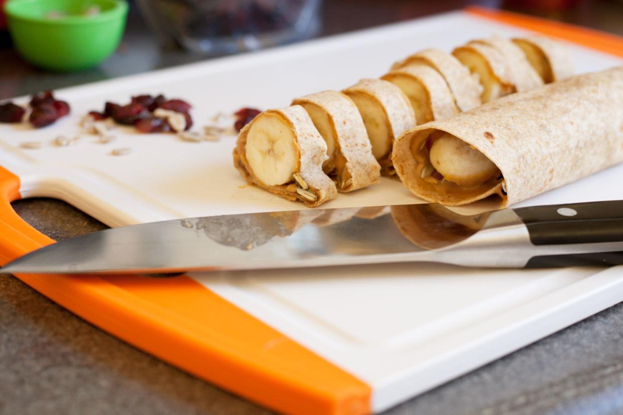 Peanut butter banana wrap chopped up for kids with a knife