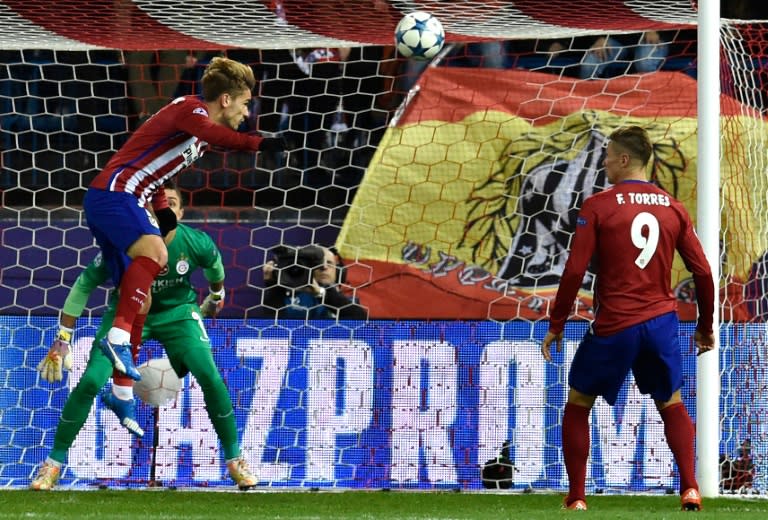 Atletico Madrid's forward Antoine Griezmann (L top) heads the ball to score a goal in front of Galatasaray's goalkeeper Fernando Muslera (L bottom) during a UEFA Champions League match at the Vicente Calderon stadium in Madrid on November 25, 2015