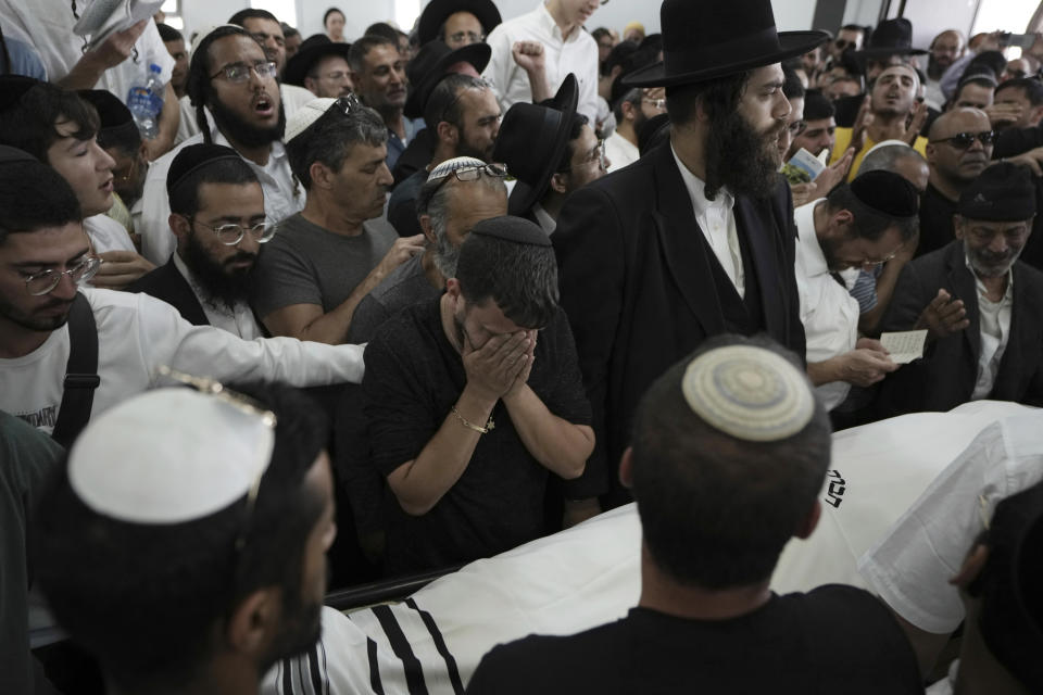 Jewish mourners gather in Petah Tikva, Israel at the funeral for Yonatan Havakuk, the day after he was killed with two others in a stabbing attack in Elad, Friday, May 6, 2022. Israeli security forces waged a massive manhunt Friday for two Palestinians suspected of carrying out the stabbing attack on Thursday near Tel Aviv that left three Israelis dead.(AP Photo/Ariel Schalit)