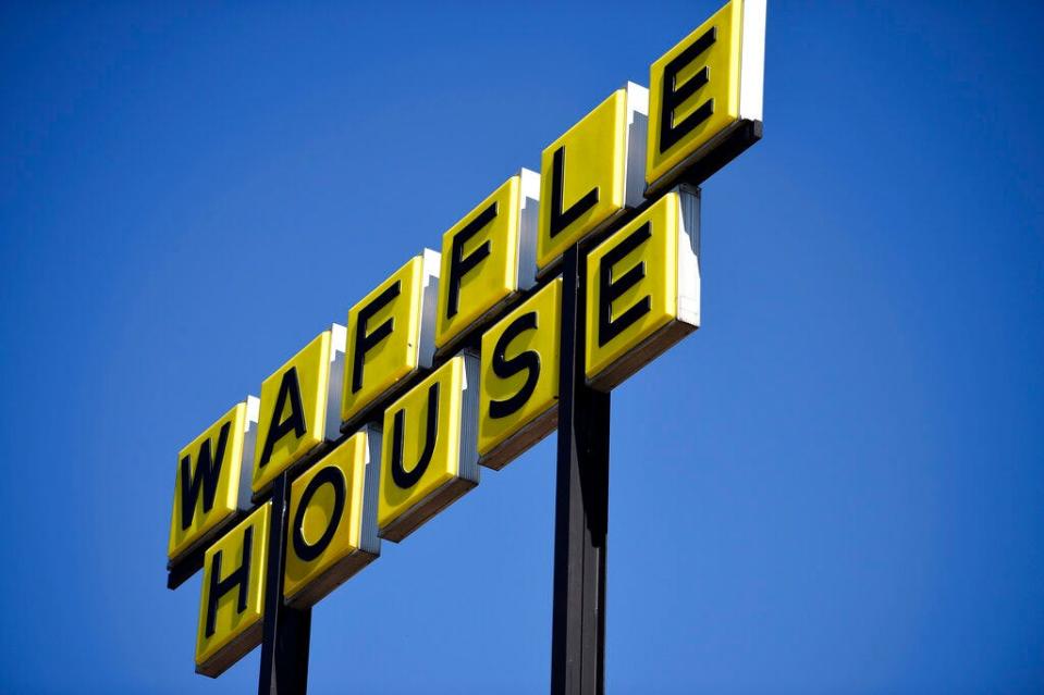 Signage is posted on the inside windown of a Waffle House restaurant, near Kennesaw State, Wednesday, March 25, 2020, in Kennesaw, Ga. (AP Photo/Mike Stewart)