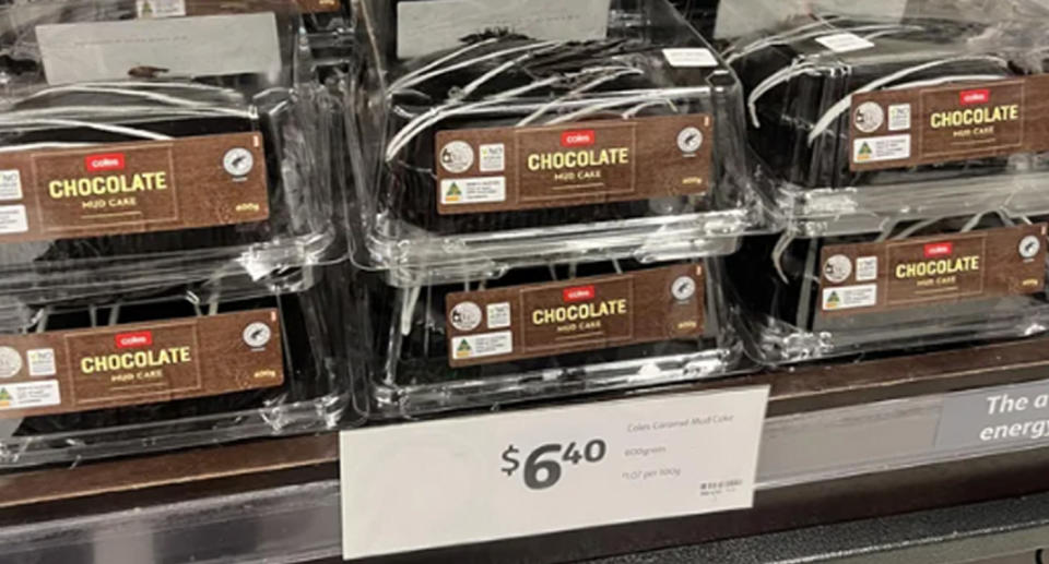 The Coles mud cake can be seen on a stacked shelf beside a price tag marked $6.40. 