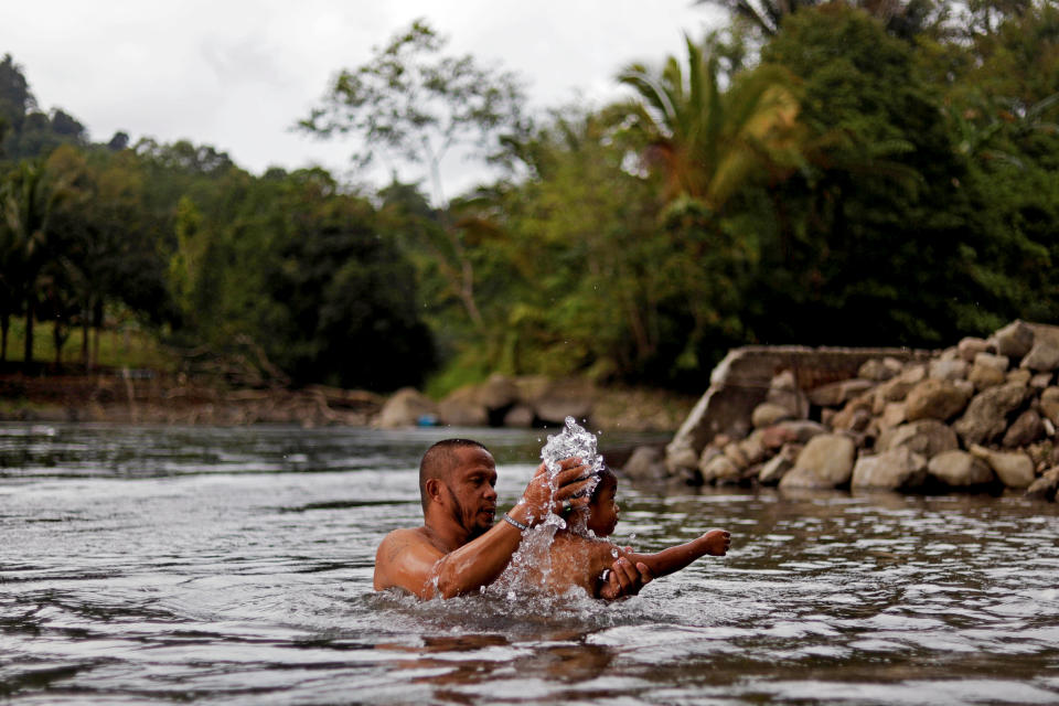 Mohammad Ali Acampong, 42, bathes his son in Rurug Agus, Marawi City, Lanao del Sur province, Philippines. (Photo: Eloisa Lopez/Reuters)