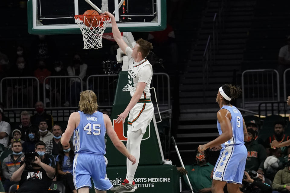 Miami forward Sam Waardenburg (21) dunks over North Carolina forward Brady Manek (45) and forward Armando Bacot (5) during the first half of an NCAA college basketball game, Tuesday, Jan. 18, 2022, in Coral Gables, Fla. (AP Photo/Lynne Sladky)