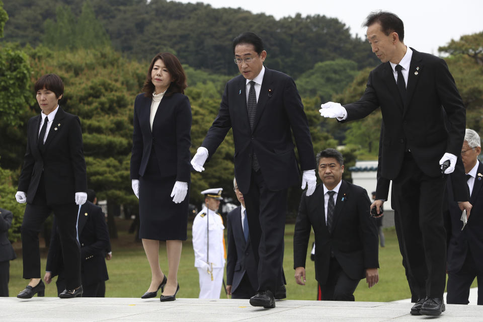 Japanese Prime Minister Fumio Kishida, center right, and his wife Yuko, center right, arrive for a visit to National Cemetery in Seoul, South Korea Sunday, May 7, 2023. The leaders of South Korea and Japan are to meet Sunday for their second summit in less than two months, as they push to bolster cooperation following years of fraught ties over historical issues. (Chung Sung-Jun/Pool Photo via AP)