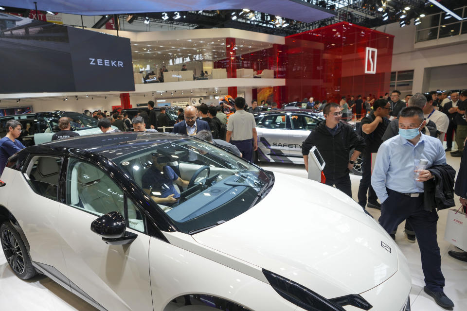 Visitors look at vehicles at the Zeekr booth during the China Auto Show in Beijing, China, Friday, April 26, 2024. China's vision of the future of the automobile electrified and digitally connected is on display at the ongoing Beijing auto show. (AP Photo/Tatan Syuflana)