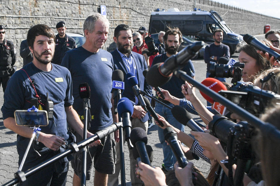 From left, Till Rummenhohl, head of operations at the SOS Humanity German charity organization, Joachim Ebeling, captain of the organization's Humanity 1 rescue ship, and their lawyer Riccardo Campochiaro talk to reporters during a press conference at the port of Catania, Sicily, southern Italy, Monday, Oct. 7, 2022. The captain of the Humanity 1, refused Italian orders to leave the Sicilian port Sunday after Italian authorities refused to let 35 of the migrants on his ship disembark — part of directives by Italy's new far-right-led government targeting foreign-flagged rescue ships. (AP Photo/Salvatore Cavalli)