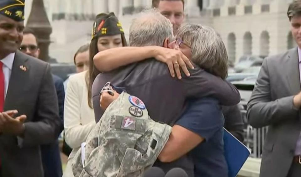 Jon Stewart and Susan Zeier, mother-in-law of late Sgt First Class Heath Robinson, share an emotional moment after the bill’s passage (NowThis News)