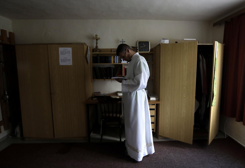 Roman Catholic priest Michal Lajcha dresses to serve a mass in a church in Klak, Slovakia, Monday, Sept. 17, 2018. Lajcha has challenged the celibacy rules practiced by the Roman Catholic Church in a rare action of dissent in the conservative Catholic stronghold in central and eastern Europe. (AP Photo/Petr David Josek)