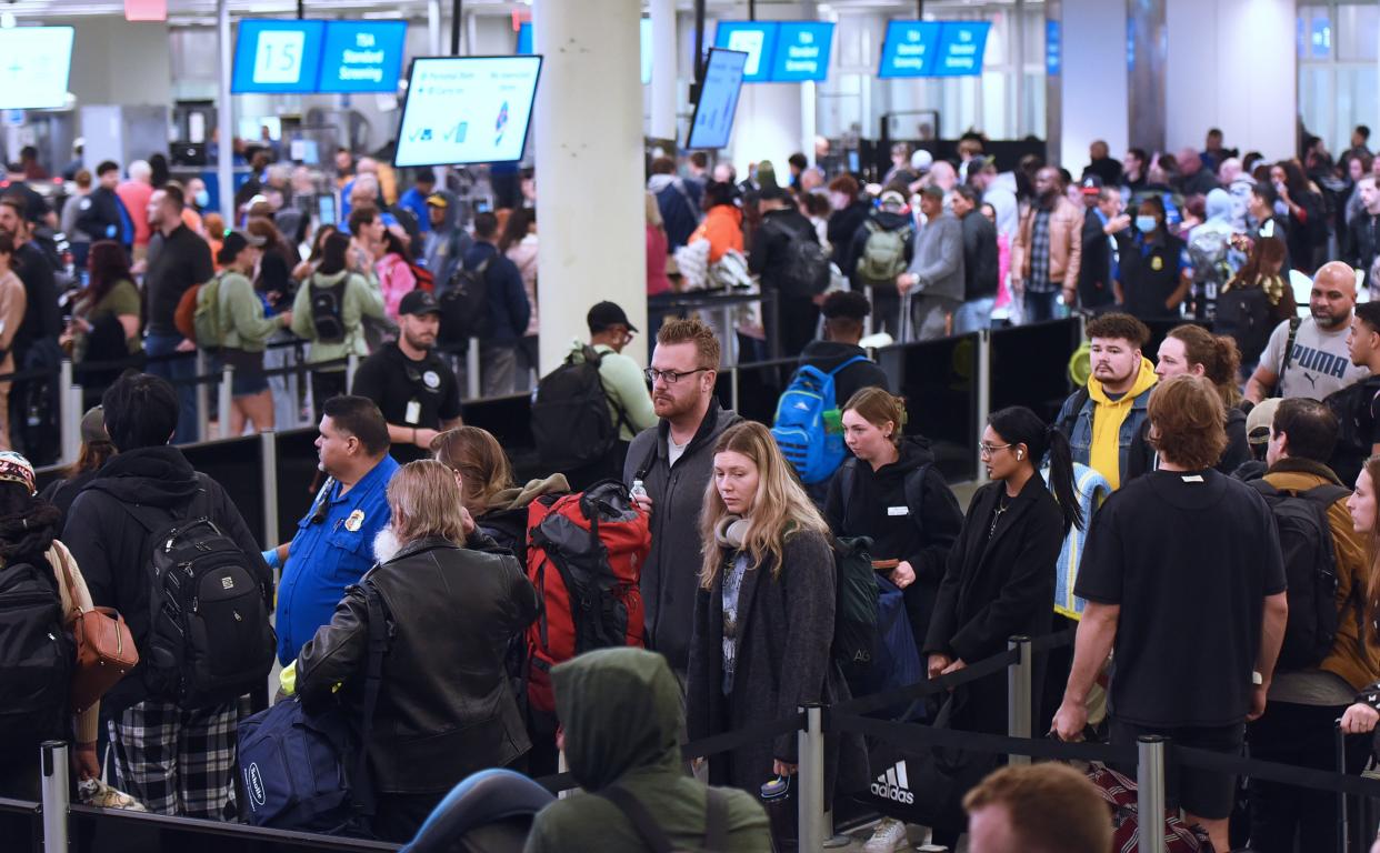 Passengers wait in the Transportation Security Administration (TSA) screening line at Orlando International Airport ahead of the Christmas holiday travel on December 22, 2023 in Orlando, Florida.