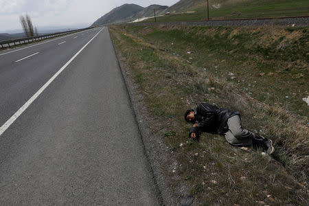 An Afghan migrant rests during a break from his walk along a main road after crossing the Turkey-Iran border near Erzurum, eastern Turkey, April 12, 2018. Picture taken April 12, 2018. REUTERS/Umit Bektas