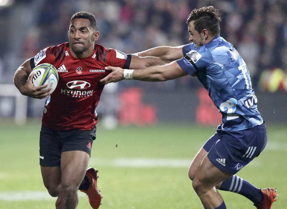 Crusaders Sevu Reece, left, runs at Blues Harry Plummer during the Super Rugby Aotearoa rugby game between the Crusaders and the Blues in Christchurch, New Zealand, Saturday, July 11, 2020. (AP Photo/Mark Baker)