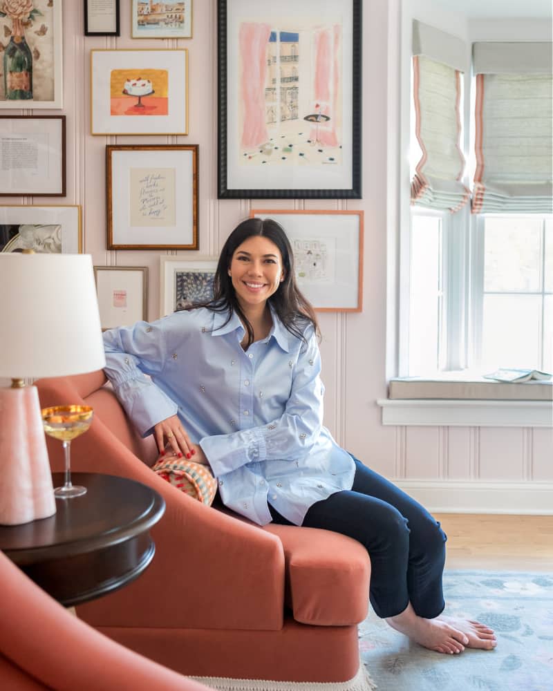 Dweller in light pink library with gallery wall.