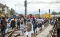 Migrants walk on train tracks towards the town of Gevgelija, Macedonia, on August 22, 2015