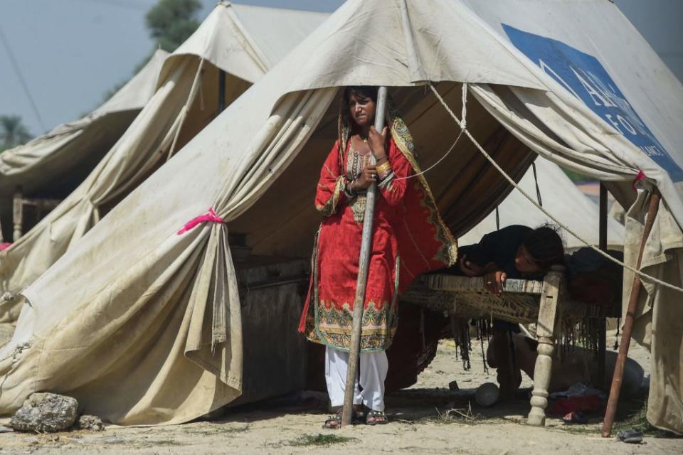 A displaced woman stands inside a tent at a makeshift camp near a flooded area following heavy monsoon rains in Rajanpur district of Punjab province on Sept. 4, 2022.<span class="copyright">ARIF ALI/AFP via Getty Images</span>