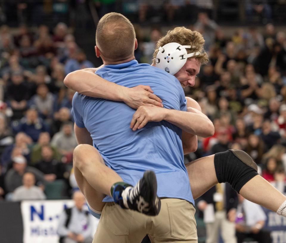 CBA 126-pounder Garrett Totten leaps into the arms of Colts' head coach Billy Ashnault after he advanced to the 126-pound state final Friday night.