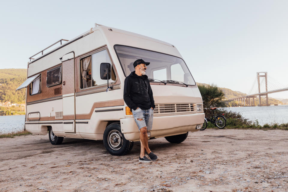 A man standing next to an RV